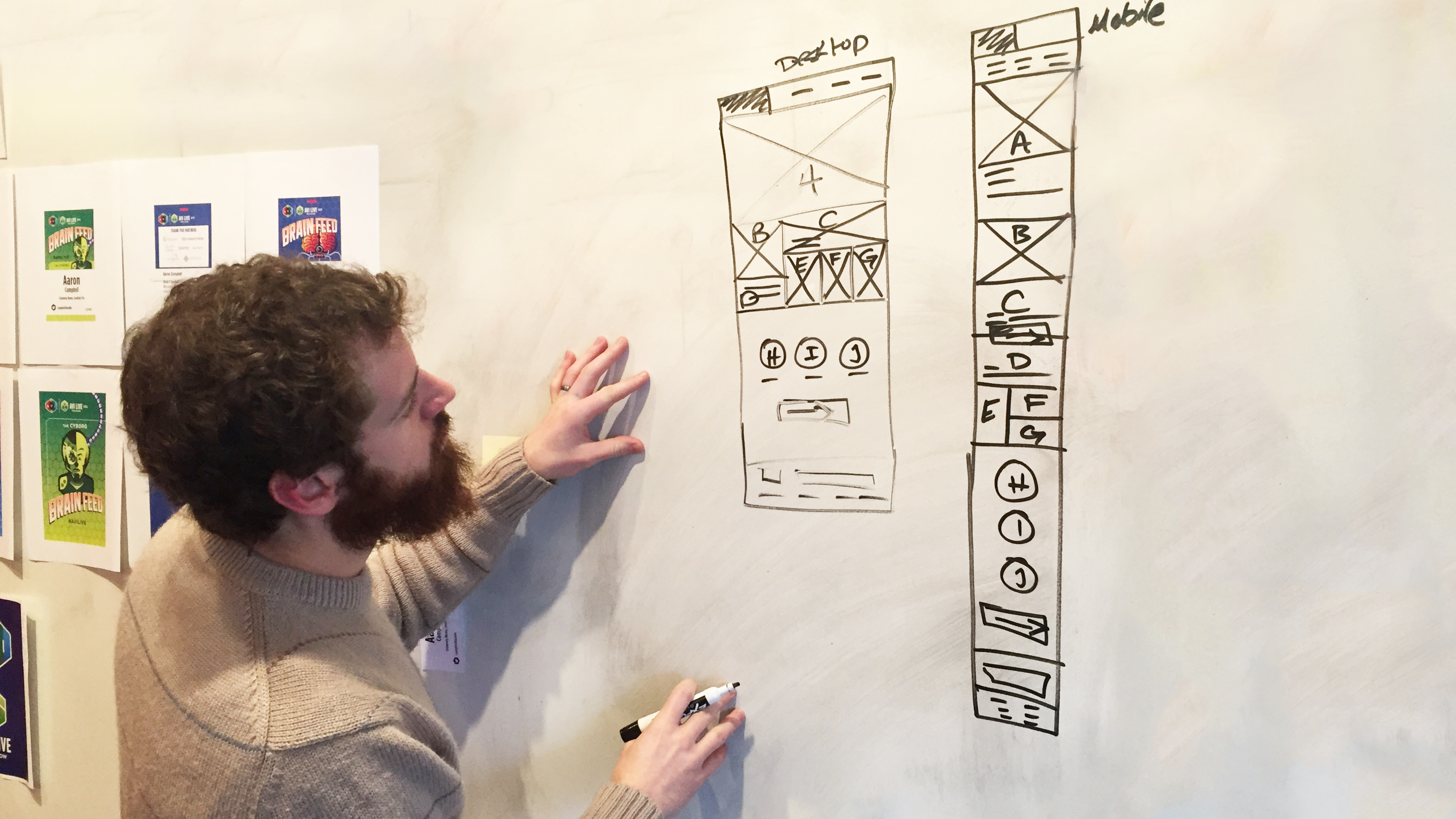 Designer sketching website wireframes on whiteboard